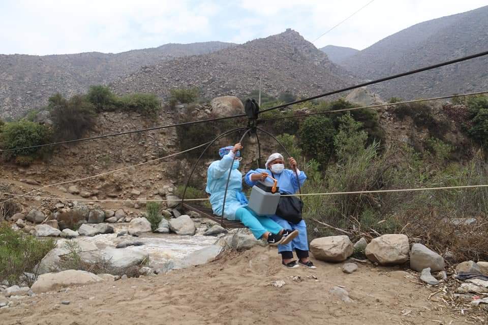 Enfermeras cruzan río con un arnés para ir a vacunar contra la covid 19